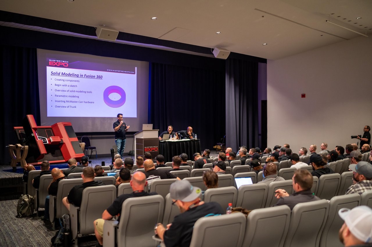 A presenter speaking to attendees in a Mesa conference venue